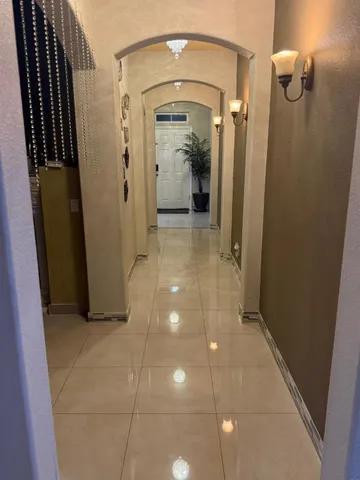 a view of a hallway with wooden floor and glass door