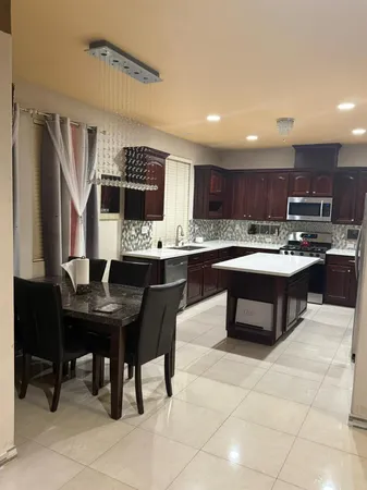 a kitchen with kitchen island a sink table and chairs
