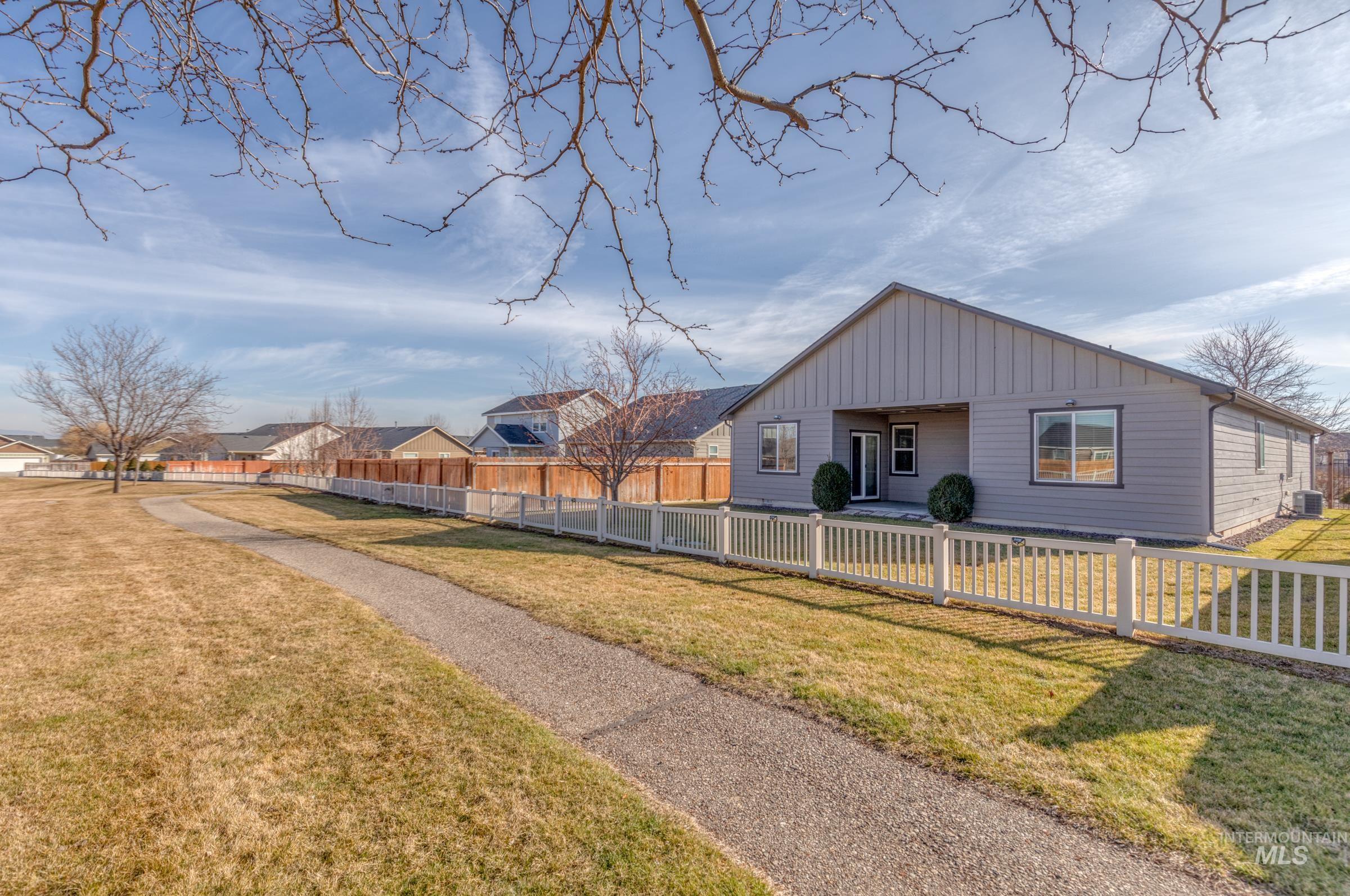 12734 Amber Sky Drive Caldwell, ID 83607 - Photo 24 of 28 Back of house with a fenced front yard, a residential view, and board and batten siding
