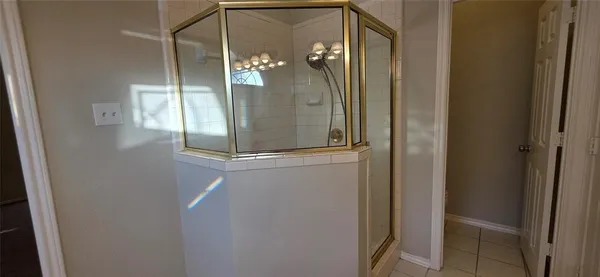 a bathroom with a glass shower door and mirror
