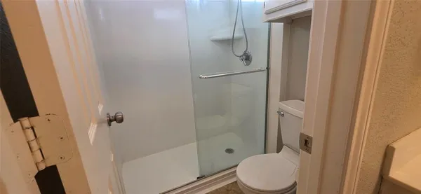 a bathroom with a shower toilet and sink