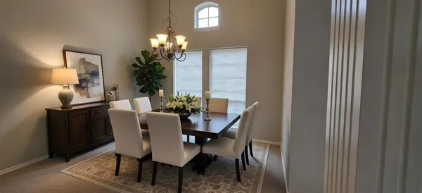 a view of a dining room with furniture and a chandelier