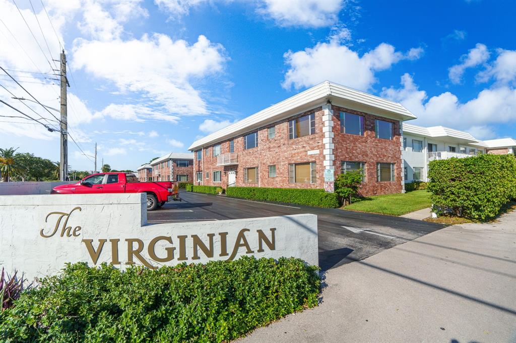 a view of sign board with buildings in the background