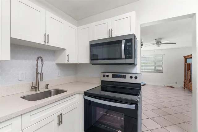 a kitchen with stainless steel appliances a stove a sink a microwave and cabinets