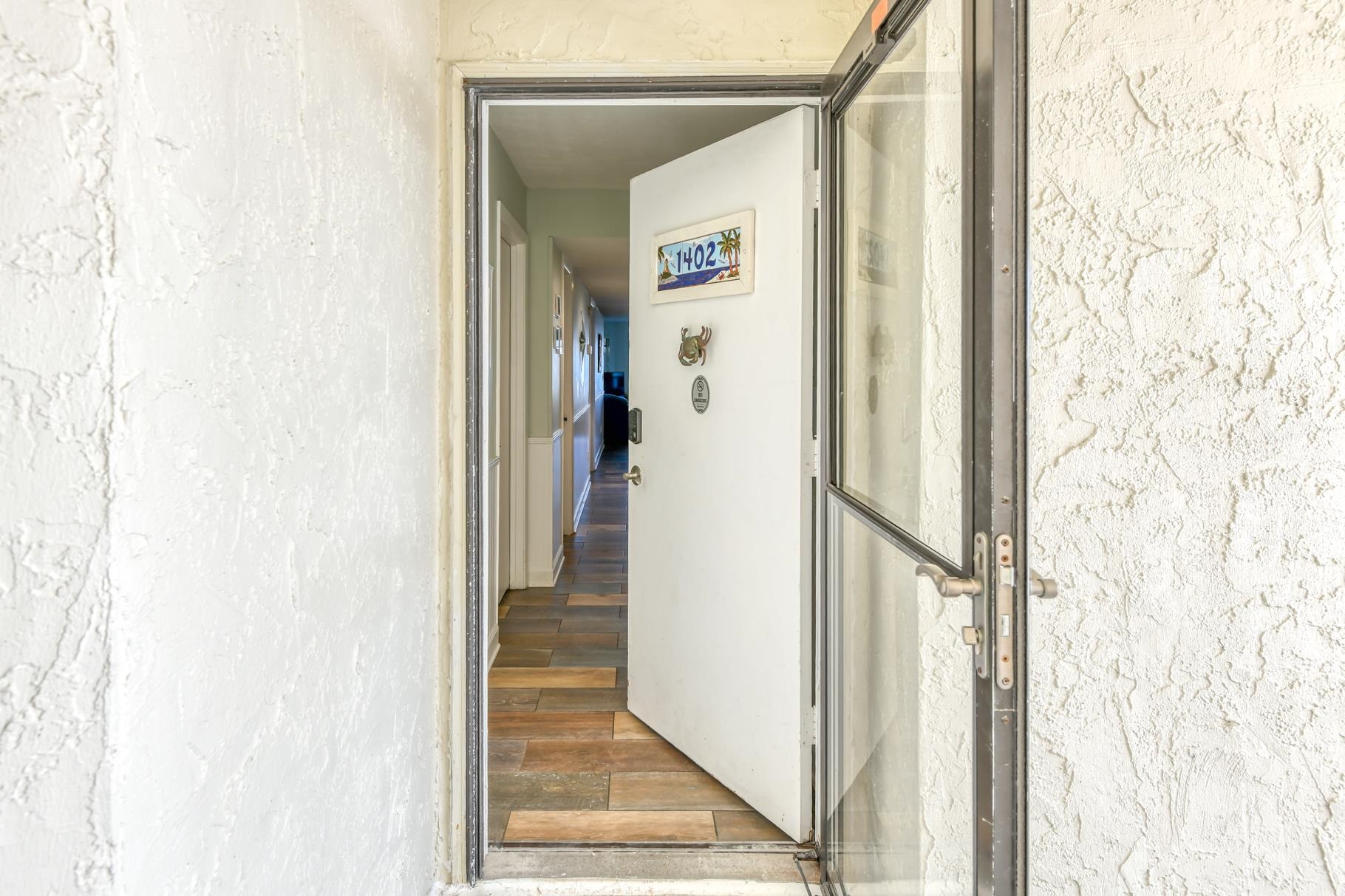 4670 A1A South, Unit 1402 St. Augustine, FL 32080 - Photo 2 of 47 a view of a hallway with wooden floor and door