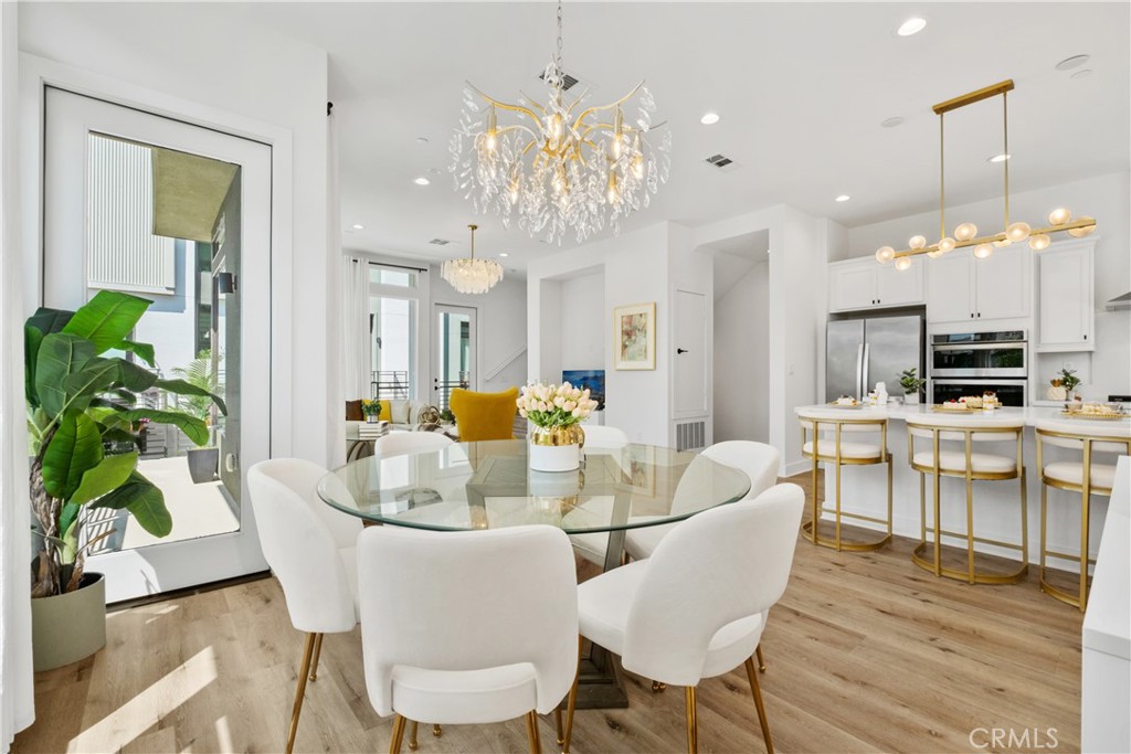 154 Keeper Irvine, CA 92618 - Photo 14 of 42 a view of a dining room with furniture a chandelier and wooden floor