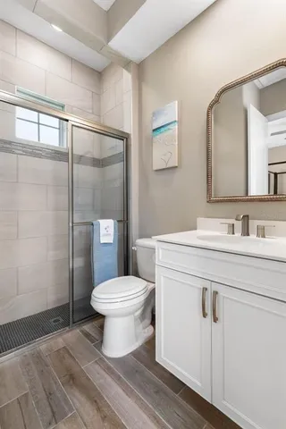 a bathroom with a granite countertop sink toilet and shower