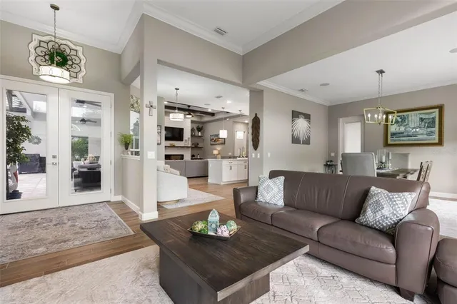 a living room with stainless steel appliances kitchen island a flat screen tv and a couch