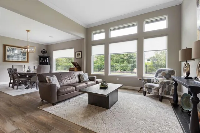 a kitchen with stainless steel appliances kitchen island granite countertop a refrigerator a stove a microwave oven a dining table and chairs with wooden floor