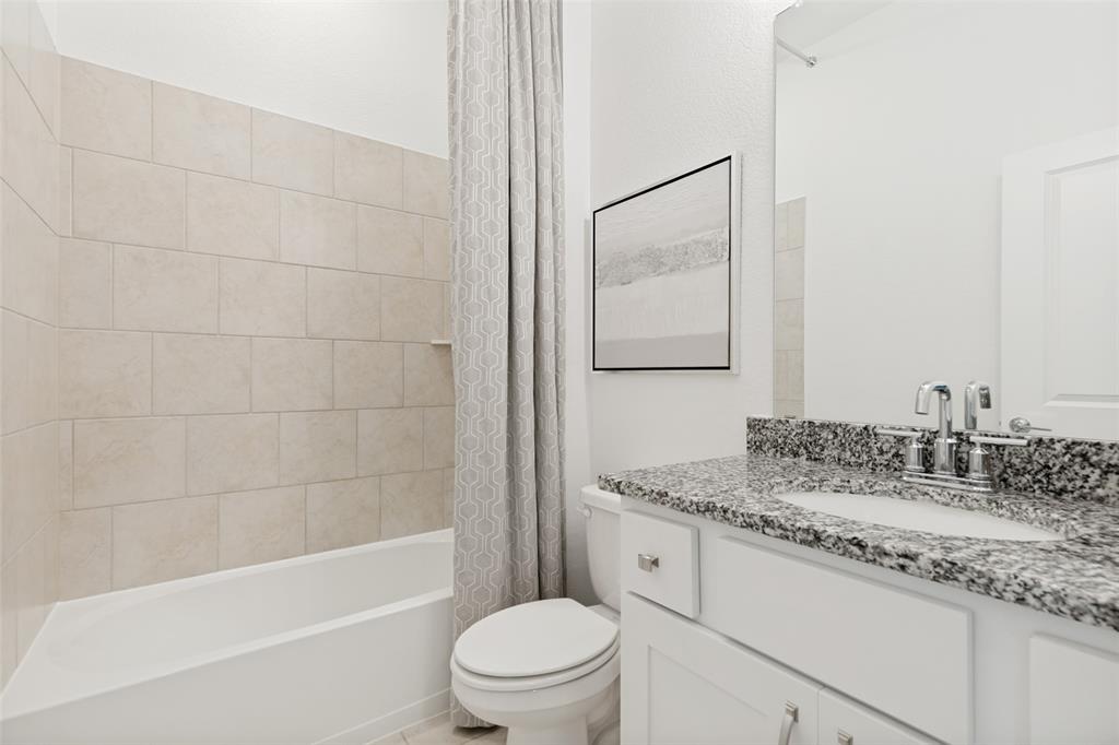229 Savannah Lane Oak Point, TX 75068 - Photo 18 of 26 a bathroom with a granite countertop sink a toilet and bathtub