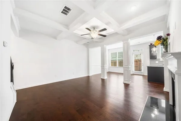 a view of an empty room with window and wooden floor