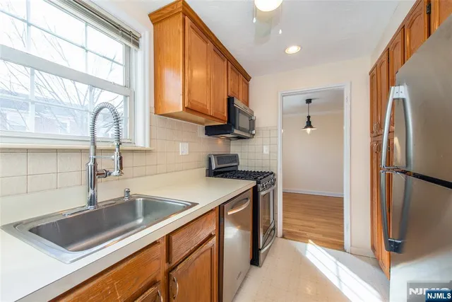 a kitchen with stainless steel appliances granite countertop a sink a stove and a refrigerator