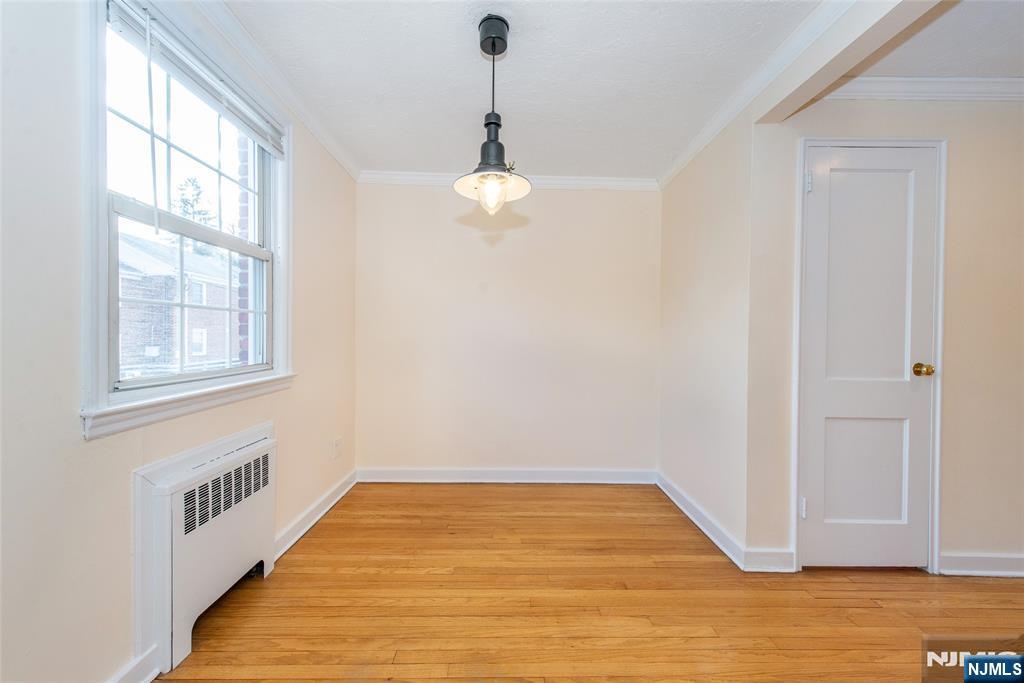 445 Morris Avenue, Unit 7C Springfield, NJ 07081 - Photo 9 of 16 a view of an empty room with wooden floor and a window