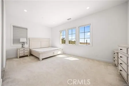 a spacious bedroom with a bed and a window