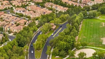 an aerial view of residential houses with outdoor space and trees