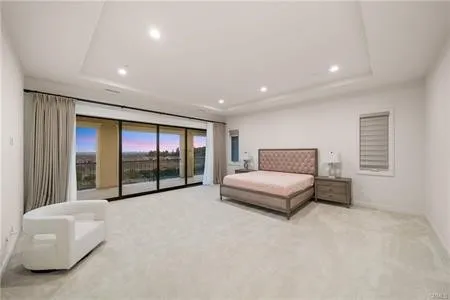 a spacious bedroom with a bed and a large window