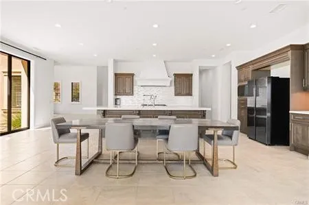 a dining hall with stainless steel appliances kitchen island granite countertop a dining table chairs and view living room