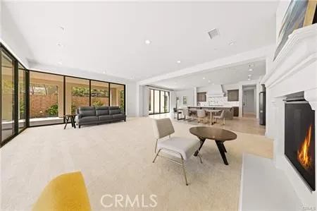 a living room with furniture a flat screen tv and a floor to ceiling window