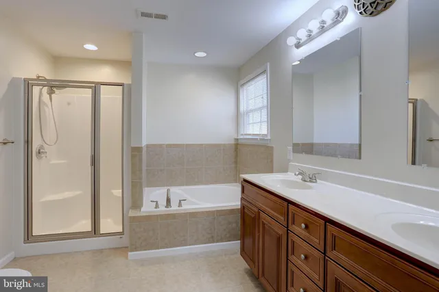 a bathroom with a tub sink and mirror