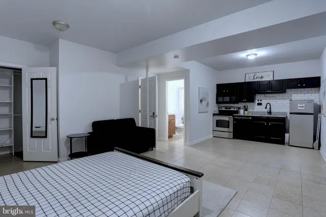 a kitchen with stainless steel appliances kitchen island granite countertop a refrigerator and a sink