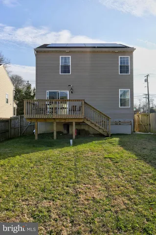 a view of a house with wooden deck and a yard