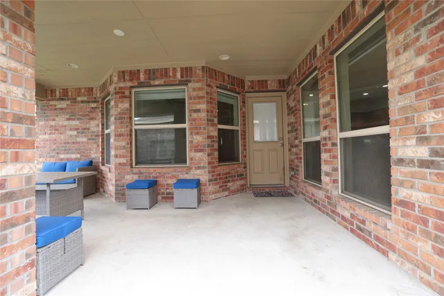 a building outdoor space with patio furniture and potted plants