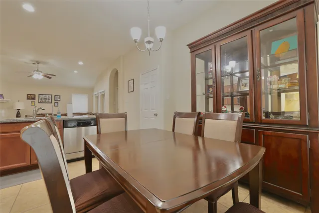 a kitchen with a dining table chairs and refrigerator