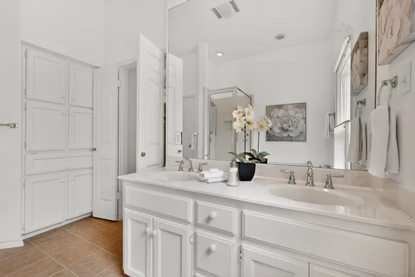 a bathroom with double vanity sink and a mirror