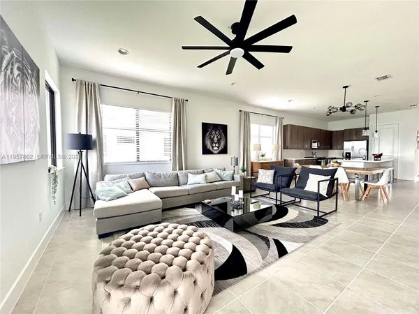 a living room with furniture and kitchen view