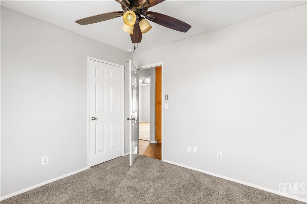 Undisclosed Address Tehachapi, CA 93561 - Photo 13 of 32 an empty room with a chandelier fan and a ceiling fan