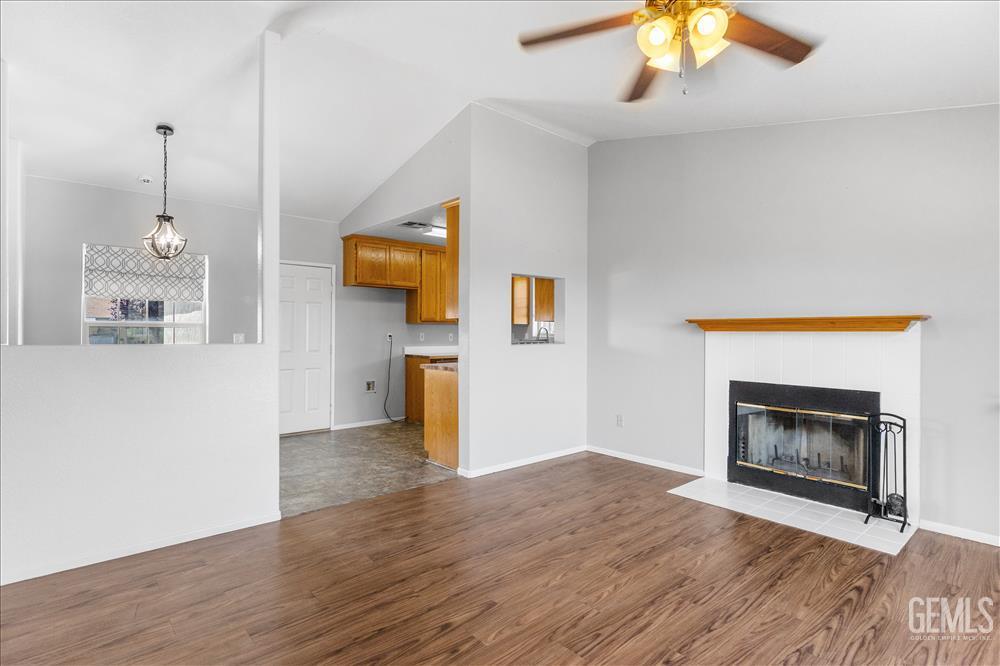 Undisclosed Address Tehachapi, CA 93561 - Photo 8 of 32 a view of empty room with wooden floor and fireplace