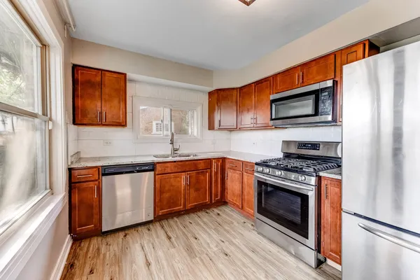 a kitchen with stainless steel appliances granite countertop a stove a sink and a microwave