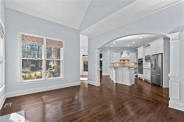 a view of an empty room with window and wooden floor