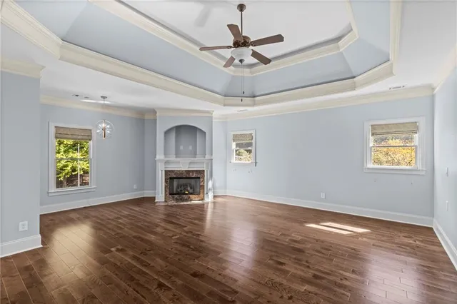 an empty room with wooden floor and ceiling fan