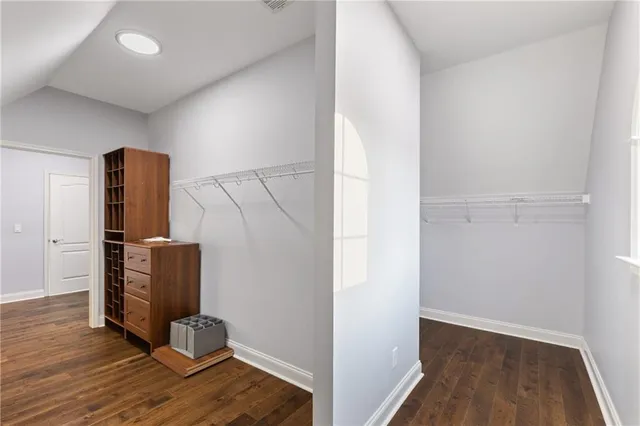 a view of an empty room with chandelier fan and windows