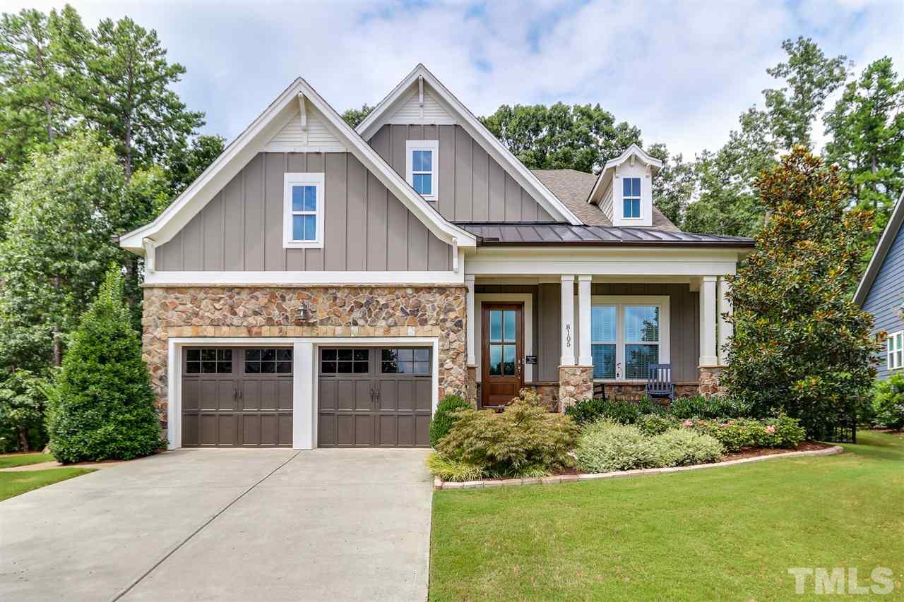 a front view of a house with a garden and garage