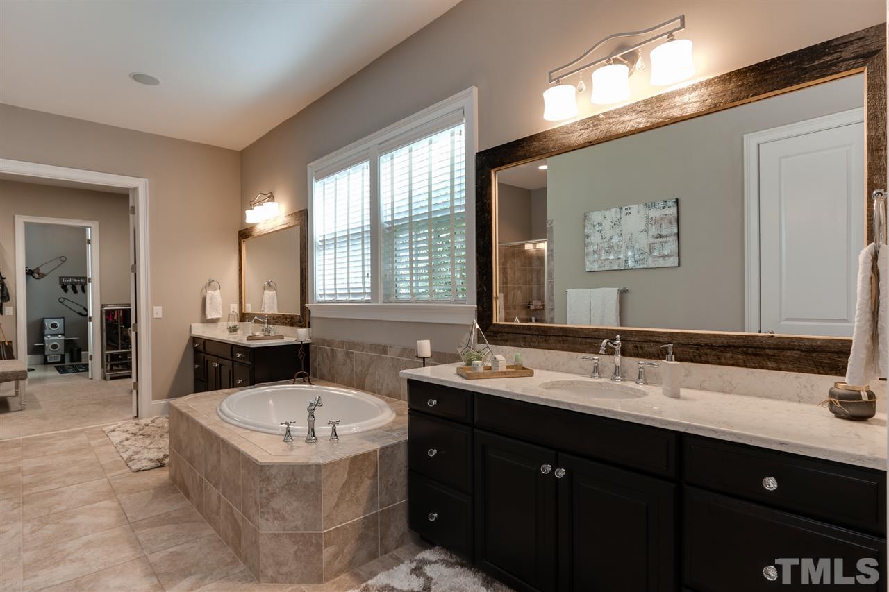 8105 Greys Landing Way Raleigh, NC 27615 - Photo 15 of 30 a bathroom with a tub sink and mirror