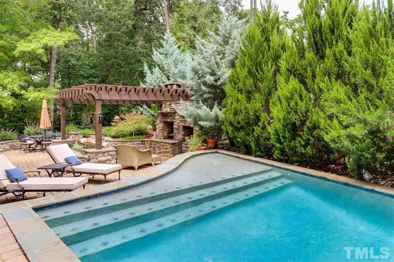 8105 Greys Landing Way Raleigh, NC 27615 - Photo 26 of 30 a view of a patio with lawn chairs under an umbrella