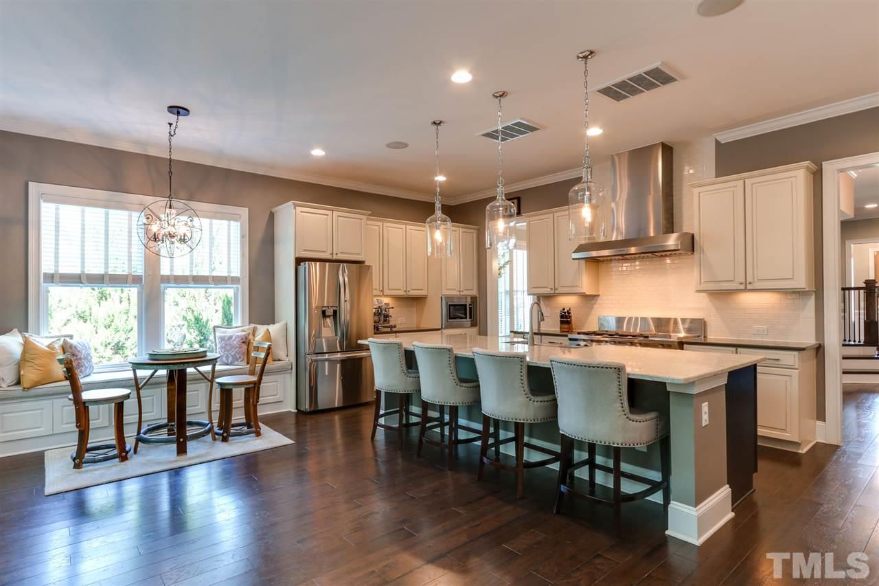 8105 Greys Landing Way Raleigh, NC 27615 - Photo 6 of 30 a kitchen with stainless steel appliances a dining table chairs stove refrigerator and cabinets