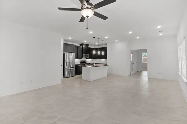 a view of a kitchen with a refrigerator and a ceiling fan