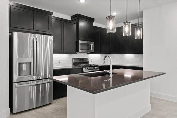 a kitchen with granite countertop a refrigerator and a sink
