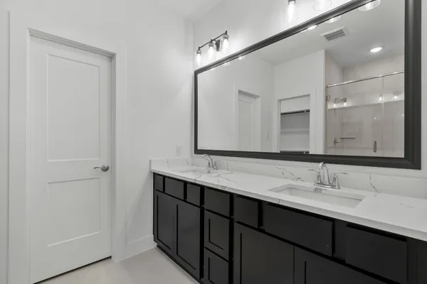 a bathroom with a double vanity sink and a mirror