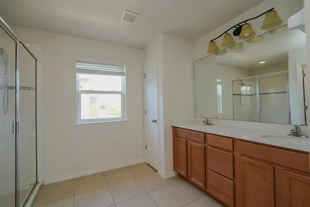 a bathroom with a double vanity sink and a mirror