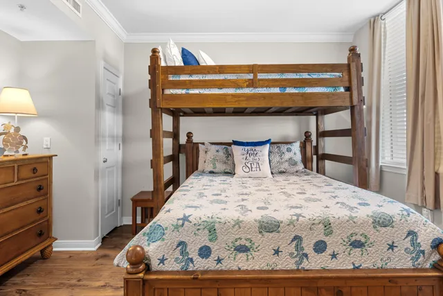 a bedroom with a bed and a lamp on dresser