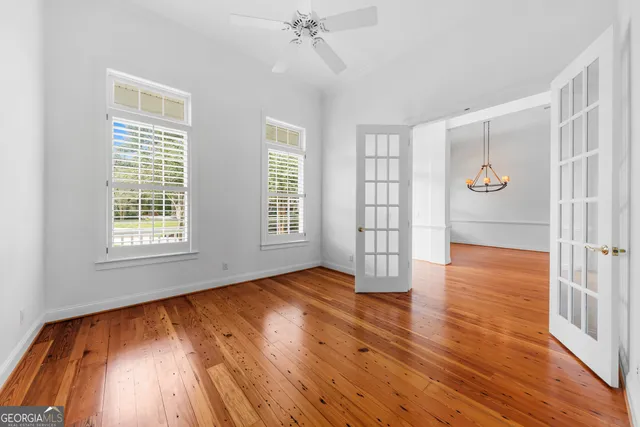 a view of room with wooden floor ceiling fan and windows