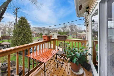 a balcony with wooden floor and outdoor seating