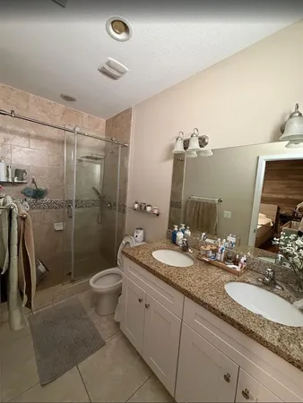 a spacious bathroom with a double vanity sink toilet and shower