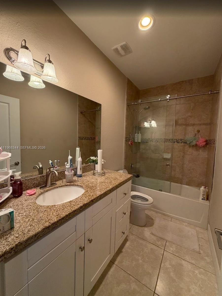12762 Southwest 248th Street Homestead, FL 33032 - Photo 10 of 17 a bathroom with a granite countertop sink a toilet a mirror and shower