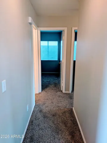 a view of a hallway with wooden floor and closet