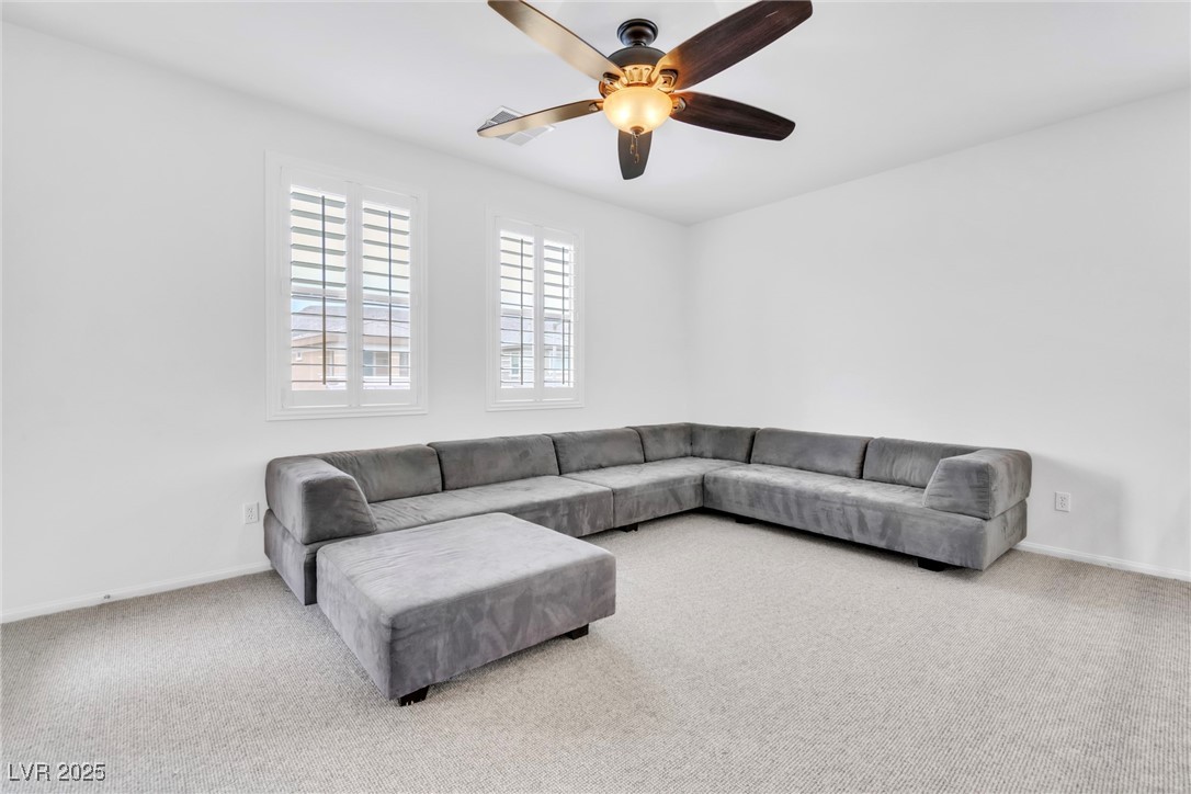 10350 Mystic Pine Road Las Vegas, NV 89135 - Photo 37 of 43 Living area featuring carpet floors, a ceiling fan